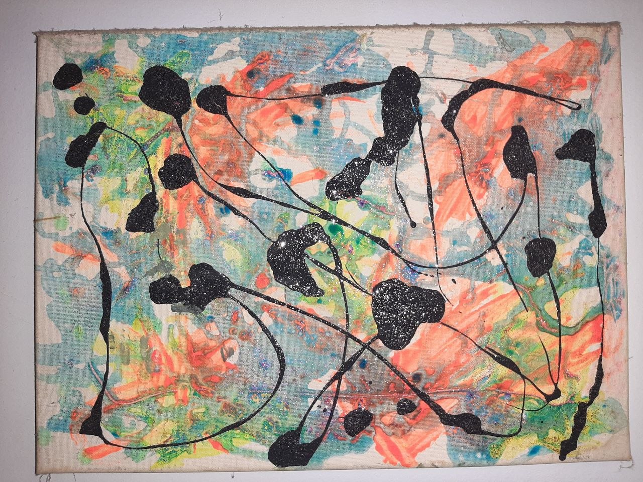 Second origin painting — coral and teal fluid wash with black glitter-textured blobs on raw canvas