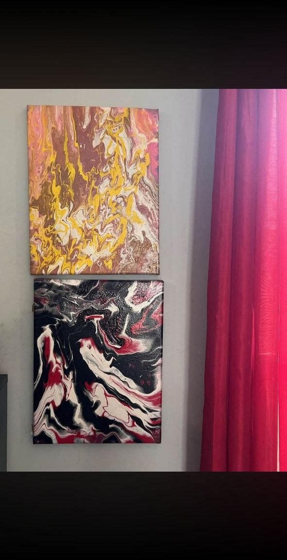 Untitled paired paintings — gold/yellow and black/red/white on wall